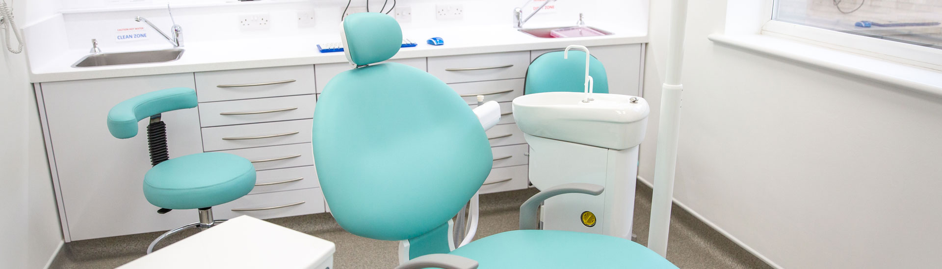 A treatment room at Hitchin Dental Care with a mint green dental chair