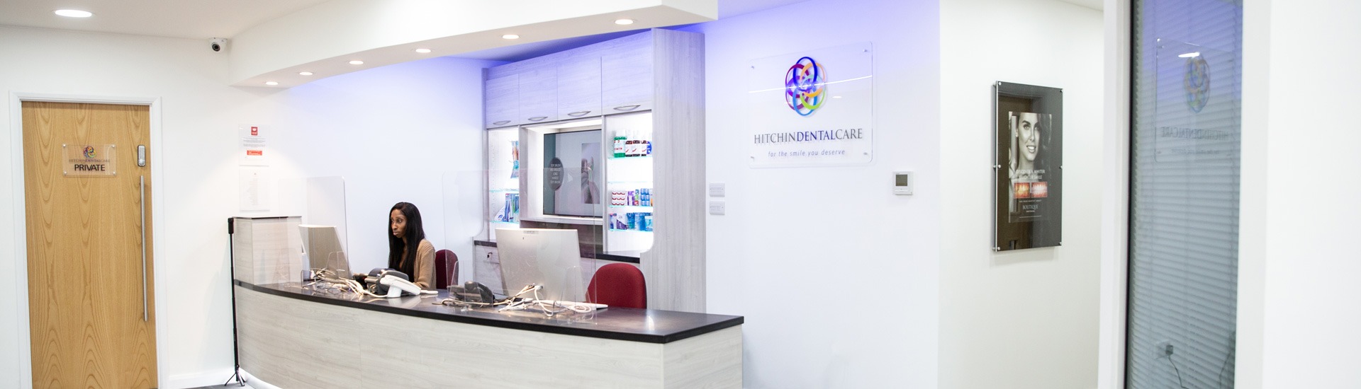 Reception at Hitchin Dental Care, with a receptionist at the front desk