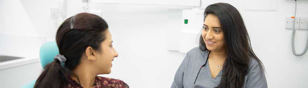 A clinician at Hitchin Dental Care in consultation with a patient