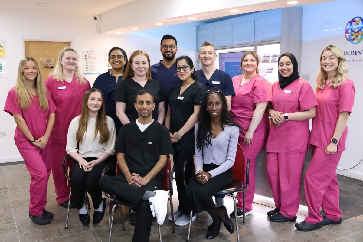 The whole Hitchin Dental Care team gathered in the practice reception, waving at the camera